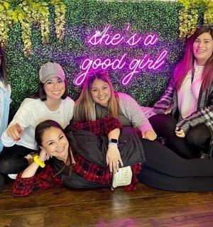 a group of girls sitting on the floor in front of a wall