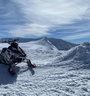 一辆雪地自行车停在白雪皑皑的山顶上