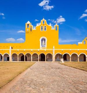 a large yellow building with a blue sky in the background