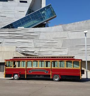 a red and yellow bus parked in front of a building