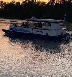 a ferry boat on a river at sunset