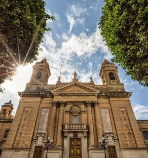 velká cihlová budova se sluncem za ní