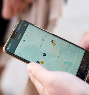 osoba držící mobilní telefon s mapou