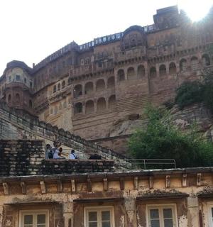 a building on a mountain with people on the stairs