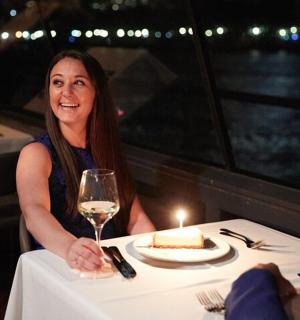 一位女士坐在桌边，手里拿着一块蛋糕