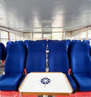 一辆空巴士,配有蓝色座椅和一张桌子