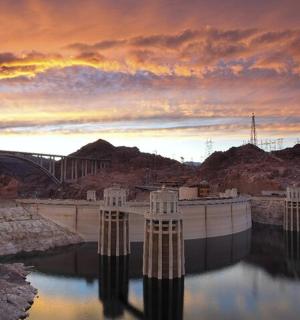 a dam in the middle of a river at sunset