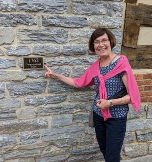a woman standing in front of a brick wall