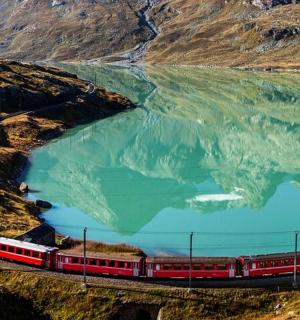 a train on the tracks next to a body of water