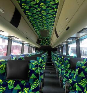 一辆空巴士,上面有蓝色和绿色的椅子