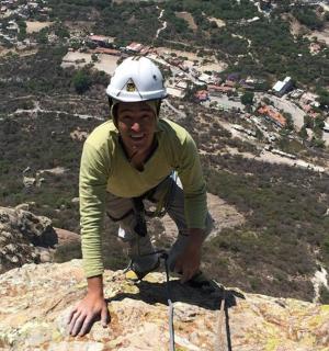 a man wearing a helmet on top of a mountain