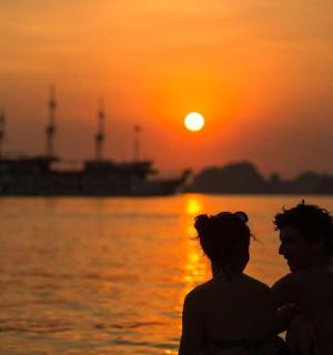 一男一女站在水边,欣赏日落