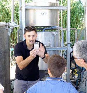 a group of people standing around a man looking at a cell phone