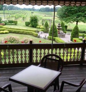 a patio with tables and chairs and a view of a garden