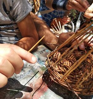 一个人正在用棍子编篮子