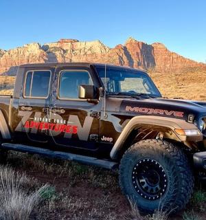 a jeep parked in a field in the desert