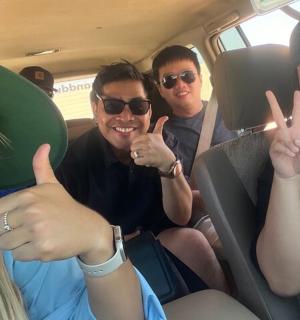 a group of people sitting in a van giving the peace sign
