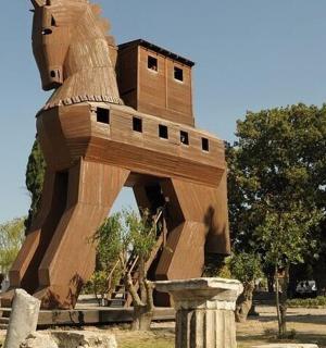 a large wooden horse statue in a park