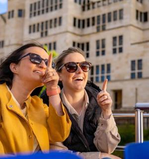 two women sitting next to each other in front of a building