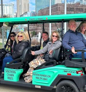 a group of people sitting in a golf cart