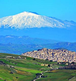 丘の上の村がある雪を頂いた山