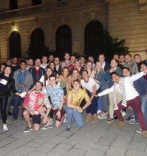 eine Gruppe von Menschen posiert für ein Foto vor einem Gebäude