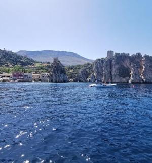 a group of boats in the water near a rocky island