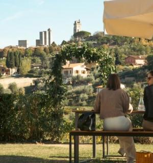 dvě ženy sedící na lavičce pod slunečníkem