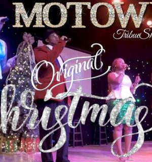 一群人站在舞台上，手里拿着圣诞快乐的标志