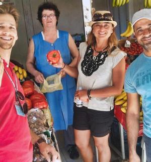 a group of people standing in a store with fruit