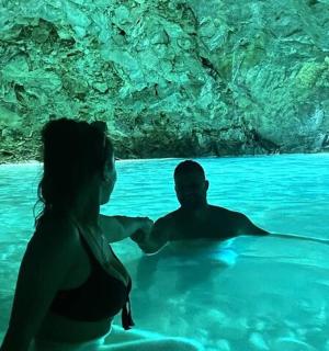 a man and woman in the water in a cave