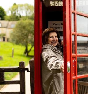 一名女子站在红色电话亭内