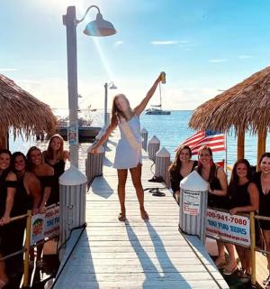 一名女子和一群女孩站在码头上