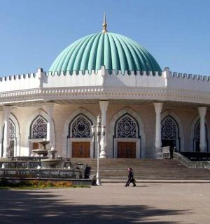 一个人走在一座绿色圆顶建筑前