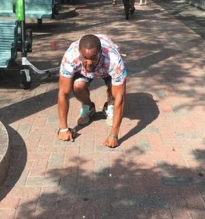 a man is bending over on a brick sidewalk