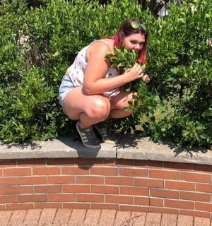 a woman is squatting on a brick wall