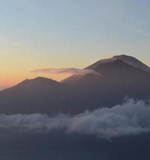 a view of a mountain with clouds in front of it