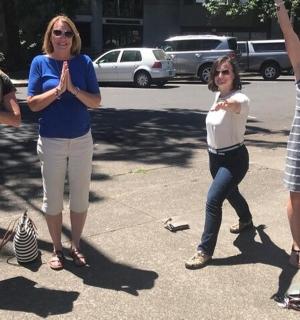 一群妇女站在停车场,举起双手