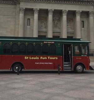 一辆红绿相间的巴士停在一栋建筑物前