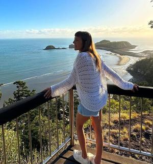 a woman standing on a balcony overlooking the ocean