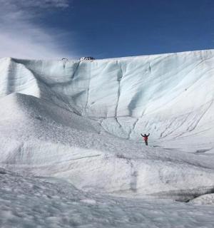 คนๆ หนึ่งยืนอยู่บนภูเขาที่ปกคลุมด้วยหิมะ