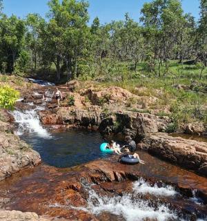 a group of people in a river with a waterfall