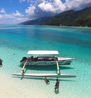 a boat on a beach with people in the water
