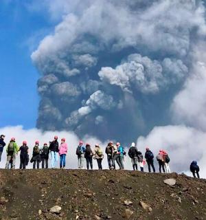 skupina lidí stojící na vrcholu kopce