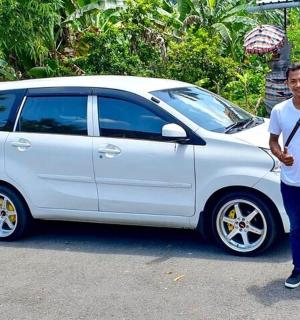 一名男子站在一辆白色汽车旁边