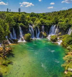 an aerial view of a waterfall in a forest