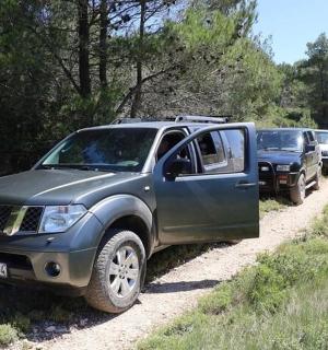 a group of cars parked on a dirt road