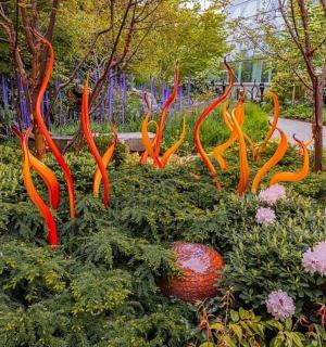 zahrada s několika oranžovými sochami v trávě