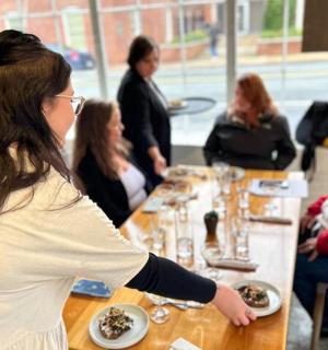 skupina lidí sedících kolem stolu s jídlem