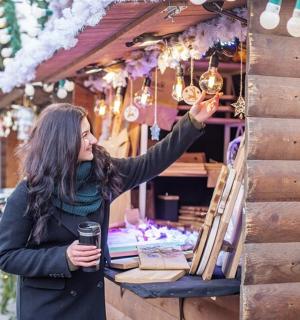 一名妇女站在市场前卖灯